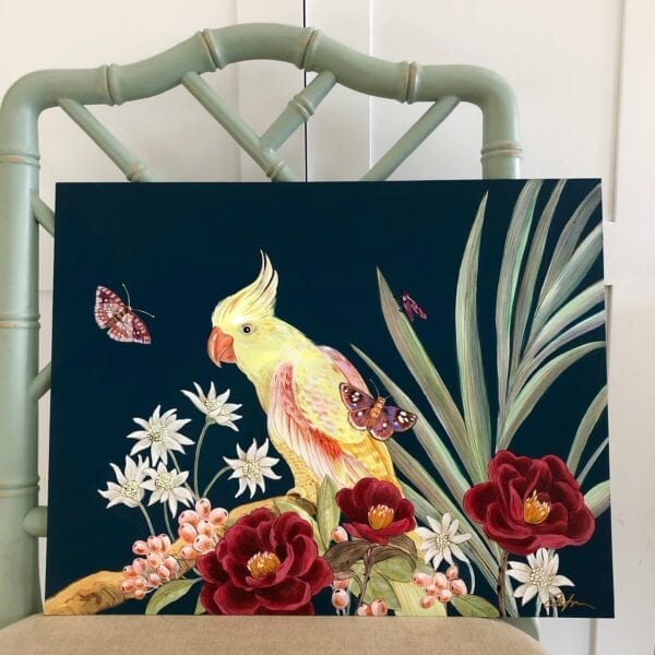 A "Tropical Therapy" parrot cockatoo painting of a yellow cockatoo perched atop a chair, surrounded by vibrant flowers.
