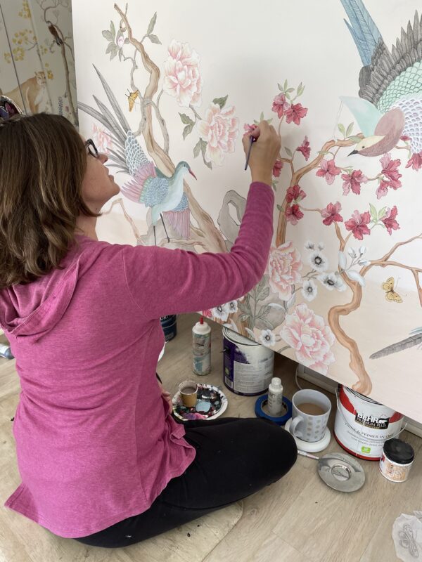 A woman painting a wall with "To be or not to be...Chat is the Question" Chinoiserie birds pink art print.